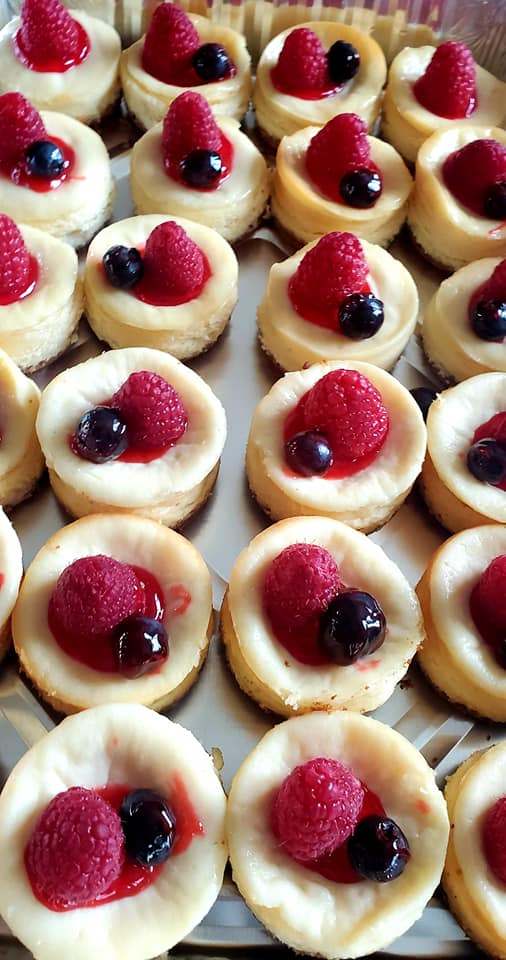 Beautiful three-tiered wedding cake with peach and blush flowers, gold 'F & D' topper